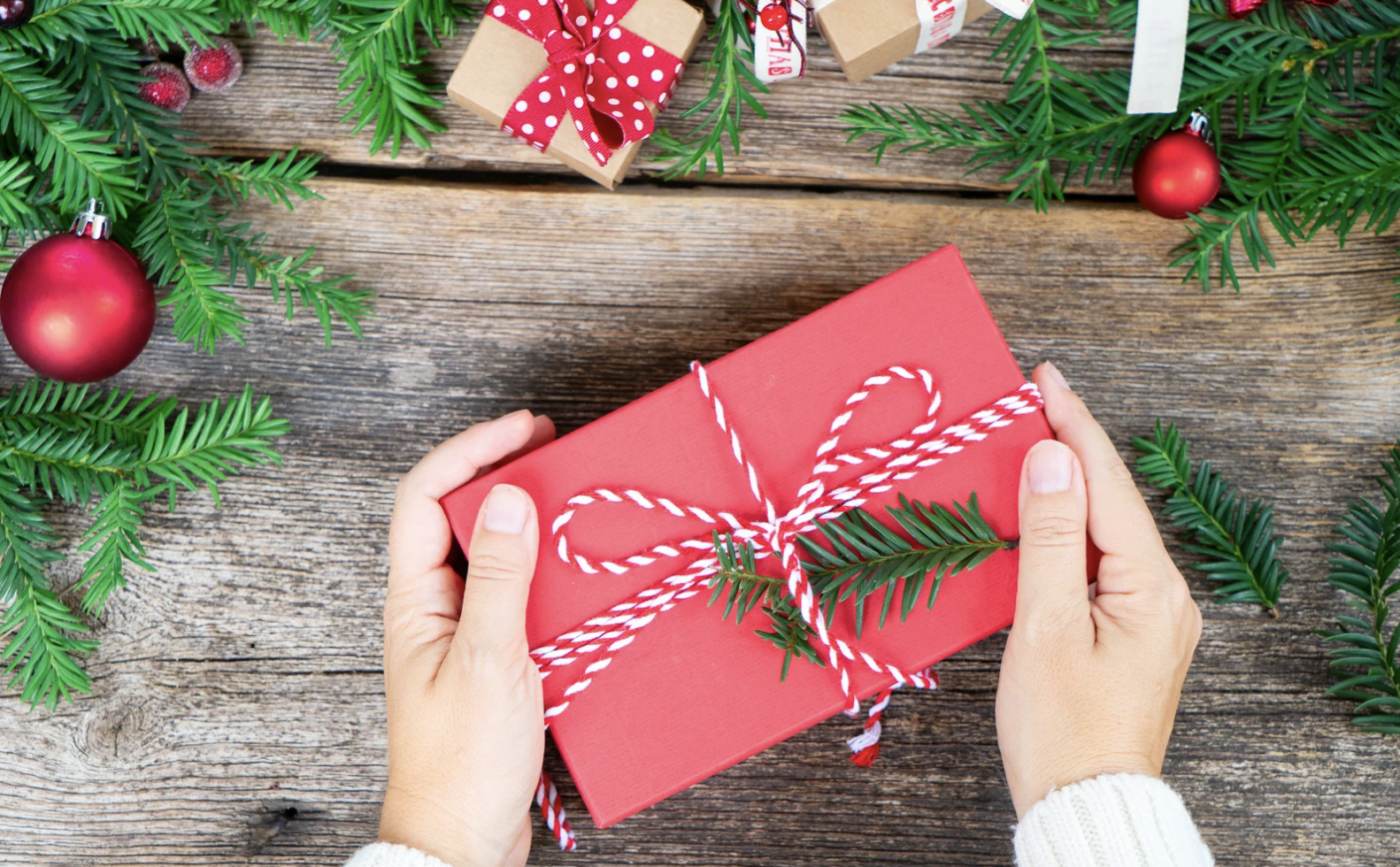 Red Christmas gift wrapped up on a wooden table