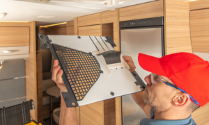 RV camper working on air conditioning maintenance